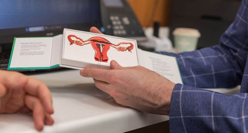 Dr Sam Holford demonstrating a Mirena placed within a model